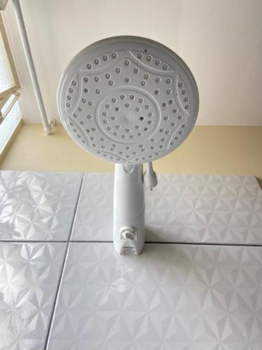 a white strainer sitting on top of a tile floor at Stylo Hotel in Juiz de Fora