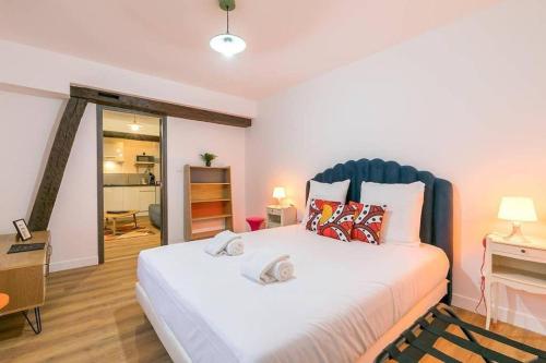 une chambre avec un grand lit blanc avec une tête de lit bleue dans l'établissement Le Sweet 70's : au coeur du centre historique, à Dijon