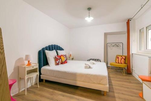 1 dormitorio con 1 cama con cabecero azul en Le Sweet 70's : au coeur du centre historique, en Dijon