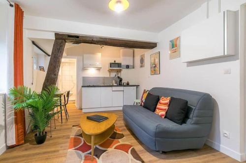 un salon avec un canapé bleu et une table dans l'établissement Le Sweet 70's : au coeur du centre historique, à Dijon