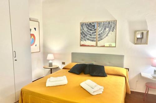 una camera da letto con un letto giallo con due asciugamani di Sweet Home Florence a Firenze