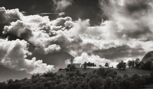 a house on top of a hill under a cloudy sky at Confrérie du Moyen Âge in Verrayes