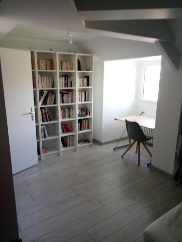 a living room with a desk and bookshelves at La maison de Séphora à 2 km du Zoo de Beauval in Saint-Aignan
