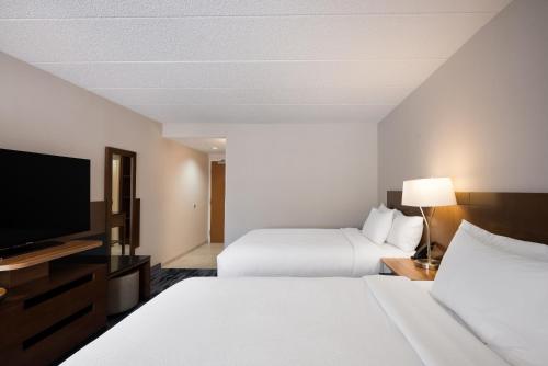 a hotel room with two beds and a flat screen tv at Fairfield Inn Boston Tewksbury/Andover in Tewksbury