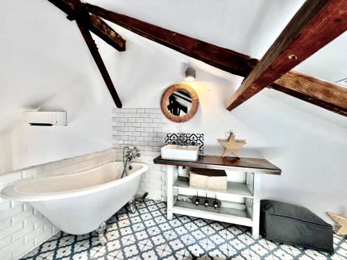 a bathroom with a white tub and a wooden ceiling at ApartHotel Riviera - V Maison Bonaparte -Vieux Port Place du Pin in Nice