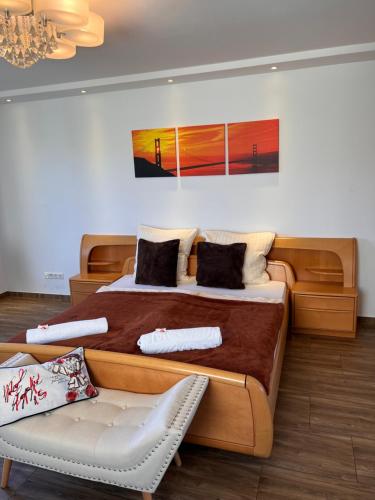 a bedroom with a large bed and a chair at LUX Business Apartments in Weil am Rhein