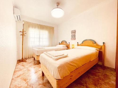a bedroom with two beds and a window at Casa junto al Mar in El Ejido