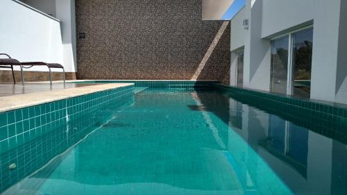 uma piscina com água azul num edifício em AlphaPark Hotel em Goiânia