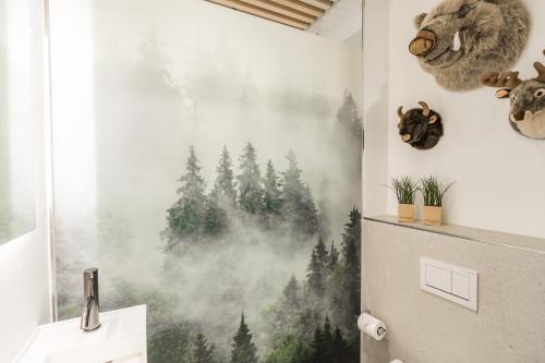 a bathroom with a forest mural on the wall at Edelbude in Oberstdorf