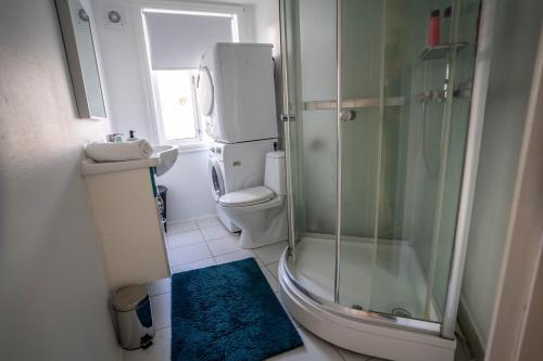 een badkamer met een douche, een toilet en een wastafel bij Central Nicolas Apartment Nr6 Stavanger 4 rooms in Stavanger