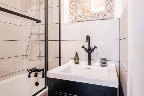 a bathroom with a sink and a bath tub at Stylish 1 Bed Flat Zone 2 Hampstead Swiss Cottage in London