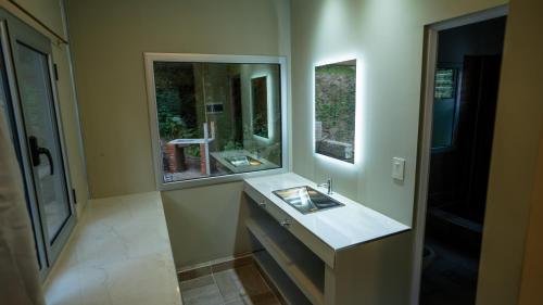 y baño con lavabo y espejo. en Eco lodge de la selva en San Salvador de Jujuy