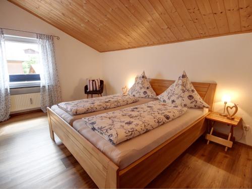 1 dormitorio con 1 cama grande y techo de madera en Ferienwohnung Hartwimmer - Chiemgau Karte en Inzell