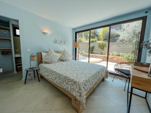 um quarto com uma cama e uma grande janela em "Grand Bleu" Villa direkt am Meer em La Seyne-sur-Mer