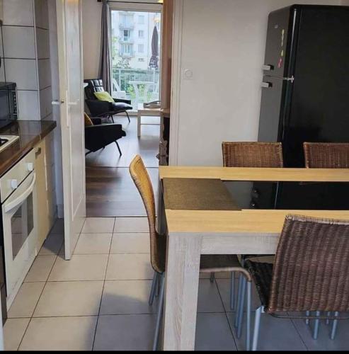 une cuisine avec une table, des chaises et un réfrigérateur dans l'établissement Agréable Appartement F3 climatisé, à Corte