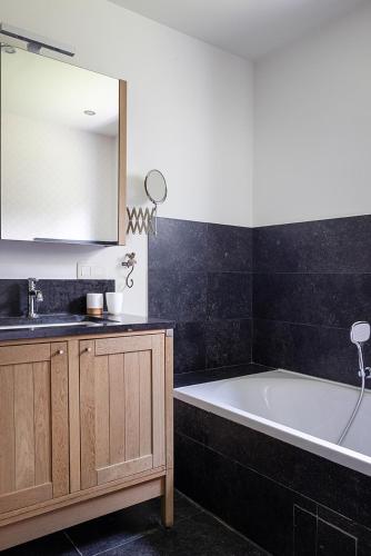 a bathroom with a sink and a bath tub at Vakantiewoning Blijbos in Oostkamp