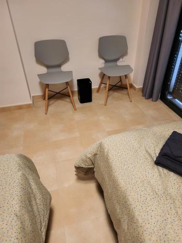 a room with two chairs and a bed in it at Hacienda de Alamo / Casa Veraneo in Fuente-Álamo de Murcia