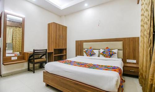 a bedroom with a large bed and a desk in it at FabHotel Silver Inn I in Bhopal