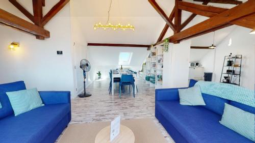 un salon avec des canapés bleus et une table dans l'établissement Le Cocon Colmarien - Proche centre ville et gare - stationnement gratuit - 10 personnes, à Colmar