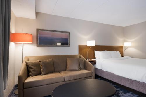 a hotel room with a bed and a couch at Fairfield Inn Boston Tewksbury/Andover in Tewksbury