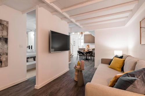 a living room with a couch and a tv on a wall at Beautiful and cosy flat La Latina-Rastro-IZQ in Madrid