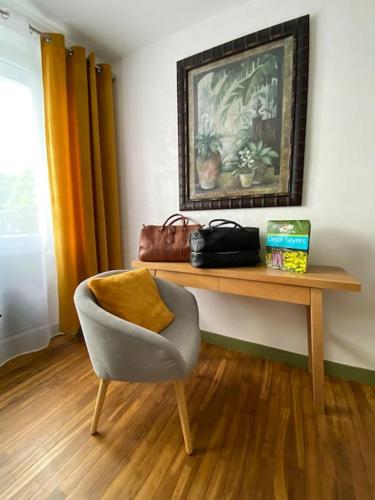 une chambre avec une chaise et une table avec une photo dans l'établissement Une pause entre Mer et Marais, à Niort