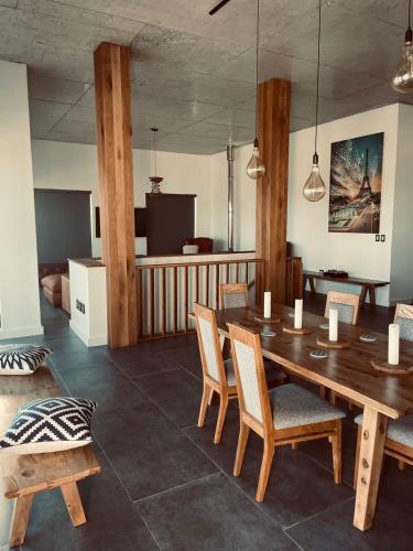 a dining room with a wooden table and chairs at Yzerfontein Villa Fantastica - No Loadshedding in Yzerfontein