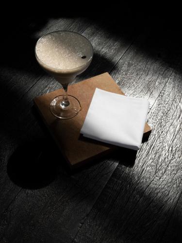 a wine glass sitting on top of a wooden table at KA BRU 1100 Boutique Hotel in Taipu