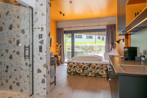 a bedroom with a bed and a kitchen with a sink at Lifesteil Aparthotel in Umhausen