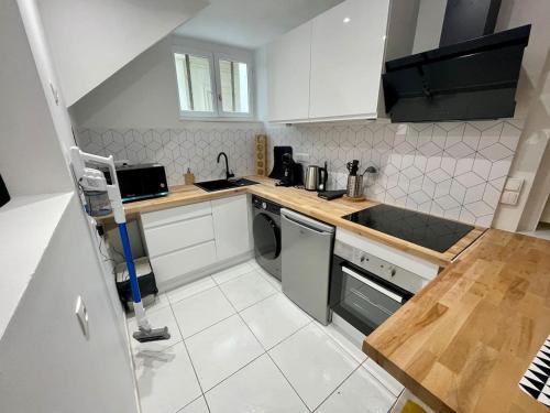 - une petite cuisine avec des placards blancs et un lave-vaisselle dans l'établissement Triplex en centre-ville - 273, à Rouen