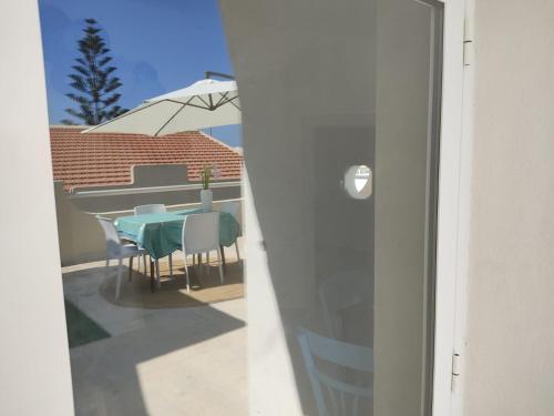 a table and chairs on a balcony with an umbrella at Brezza di mare in Punta Secca