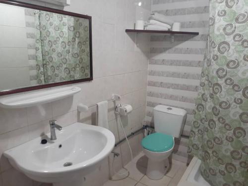 La salle de bains blanche est pourvue d'un lavabo et de toilettes. dans l'établissement HOTEL ALIA, à Djibouti