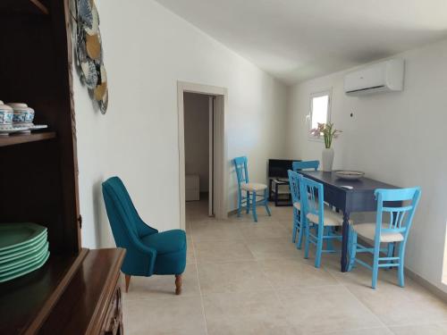 a dining room with blue chairs and a table at Brezza di mare in Punta Secca