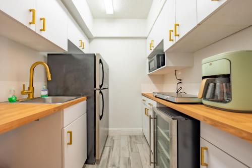 a kitchen with white cabinets and a black refrigerator at Emerald on the Water - Formerly Belleair Beach Club in Clearwater Beach