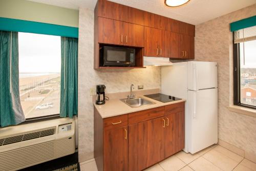 a kitchen with a sink and a white refrigerator at The Breakers Resort Inn in Virginia Beach