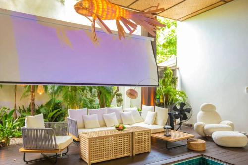 - un salon avec un canapé et un poisson sur le mur dans l'établissement Unparalleled pool villa, à Bangkok