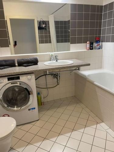 ein Badezimmer mit Waschmaschine und Waschbecken in der Unterkunft Apartment next to Mariahilferstr in Wien
