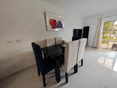 a dining room with a black table and chairs at DulceVilla_en la playa in Boca Chica