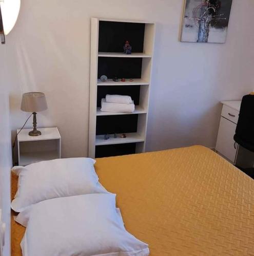 une chambre avec un lit et une table avec des oreillers dans l'établissement Agréable Appartement F3 climatisé, à Corte