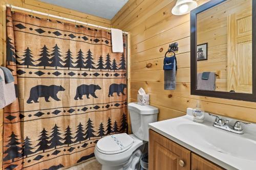 a bathroom with a toilet and a shower curtain at The Eagle's Nest Mountain Cabin Gatlinburg in Gatlinburg