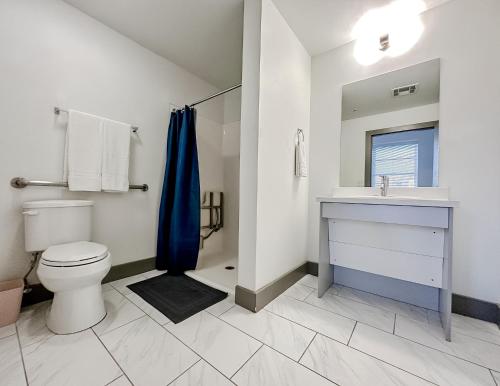 a bathroom with a toilet and a sink and a shower at Sleepover High-end Downtown Springfield Apartments in Springfield