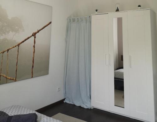 a bedroom with a bed and a curtain and a mirror at Aux portes de Nantes, 2 pièces moderne et confortable in Carquefou
