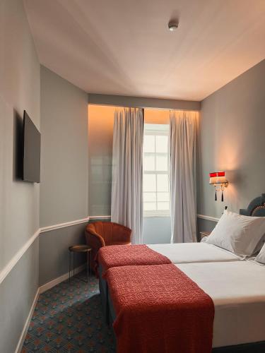 a hotel room with two beds and a window at GRANDE HOTEL PARIS by STAY HOTELS in Porto