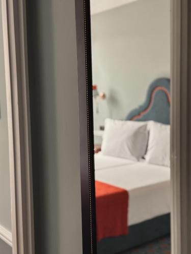 a mirror reflection of a bed in a room at GRANDE HOTEL PARIS by STAY HOTELS in Porto