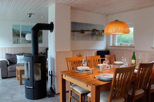 a dining room with a table and a wood stove at Huus Strandgut 9140 - Fehmarn in Avendorf auf Fehmarn
