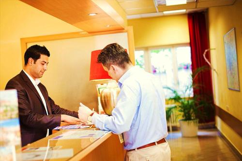 two men standing at a counter in a office at Charles Central in Prague