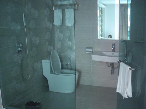 a bathroom with a toilet and a sink and a shower at Marvelot Hotel in Kajang