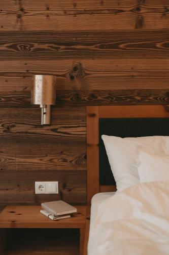 a bedroom with a bed and a table with a lamp at Hotel Rosenhof Murau in Murau