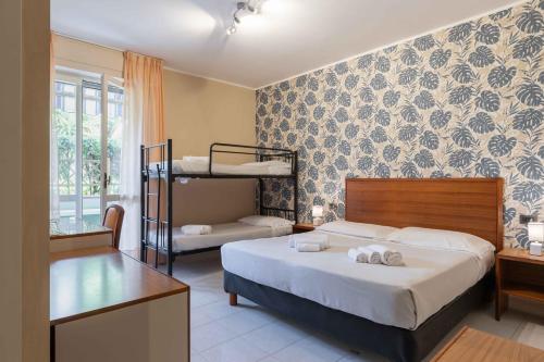 a bedroom with a bed with two bunk beds at Hotel Riva Etrusca in Marina di Bibbona