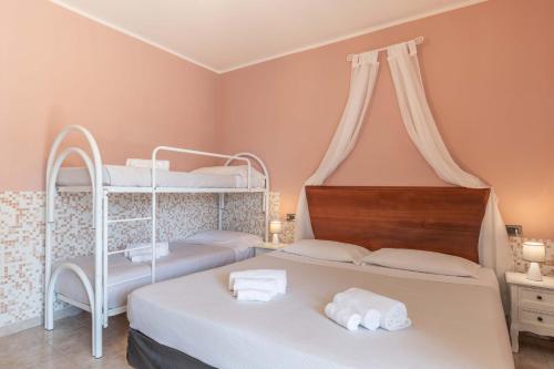two beds in a room with two bunk beds at Hotel Riva Etrusca in Marina di Bibbona